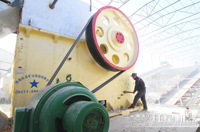 顎式破碎機生產現(xiàn)場，紅星工作人員正對設備進行檢修